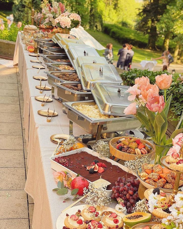 Elegant catered food spread with pastries and decorated cakes